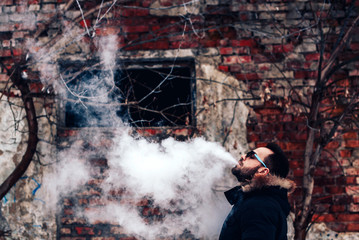 Man with beard vape electronic cigarette outdoor