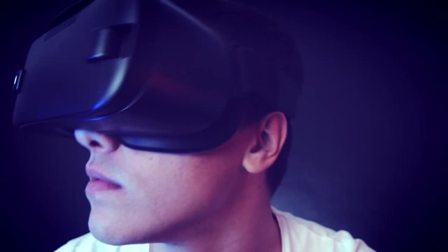 Close-up shot of a young man wearing VR Headset experiencing virtual reality. Captured with Blackmagic Production Camera 4K with RAW settings.