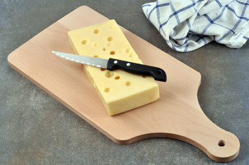 Morceau de gruyère sur une planche à découper 