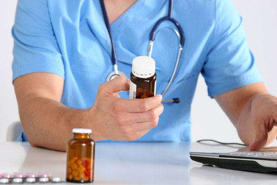 Hand of doctors holding many different pills