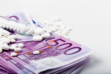 Bunch of white tablets with banknotes