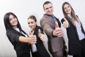 Everything is good. Successful young business team giving thumbs up.