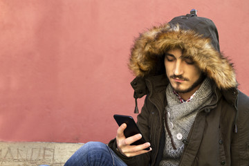 Fototapeta premium young man sitting with mobile phone