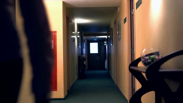 View of woman with suitcase leaves the room
