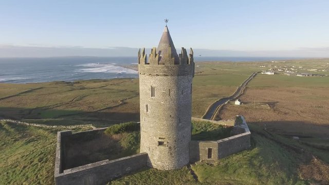 Epic Aerial Scenic Irish Castle landscape view from Doolin in County Clare. Famous tourist attraction along the wild atlantic way Ireland. Aran islands coastal beach in the distance. Flat profile 