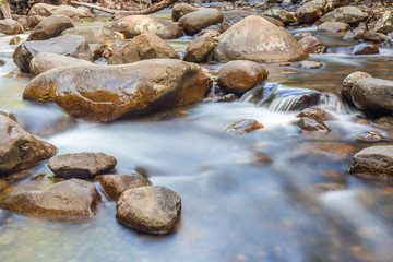 Fototapeta na wymiar Natural rocks over the flowing clear water.