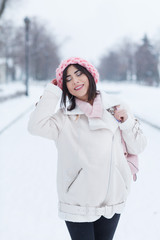 Beautiful young woman wearing merino wool pastel colors hat morning outdoors. Skin Care, Lip care, care of the eyelashes in the winter season. Beauty young woman Having Fun in Winter Park.

