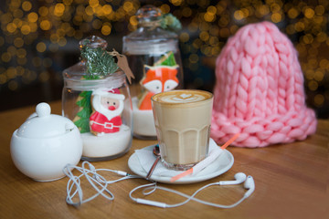 Cup of coffee and christmas decor with ginger gingerbreads on wooden table in cafe. Christmas background.

