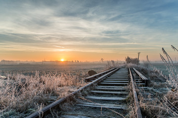 Sunrise at the forgotten railway during winter
