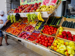 Merchant with fruit. Colorful boxes of vegetables and fruit.