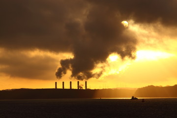 Power station on the coast at sunrise.  Global warming concept