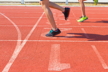 Naklejka na ściany i meble female runner feet running on track at finish line