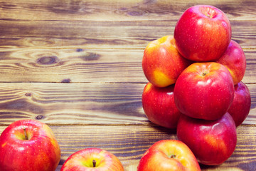 pyramid of red apples on a wooden background