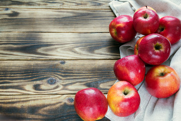 heap of red apples with white cloth on a wooden background
