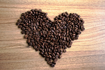 Coffee beans in a heart shape on a wooden table