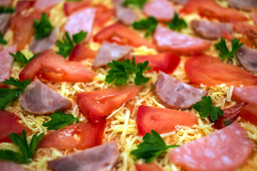  raw pizza with  salami, parmesan cheese and tomato
