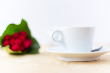 Cup with coffee, flower on wooden table in morning time