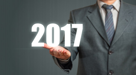 Business Man Showing Year 2017 Over Grey Background