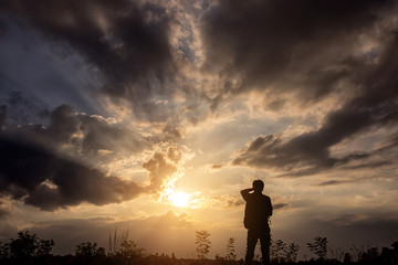 Silhouette man with backpack use smartphone in hands at sunset b