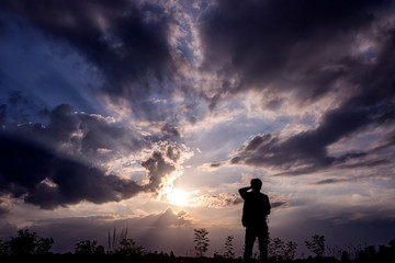 Silhouette man with backpack use smartphone in hands at sunset b