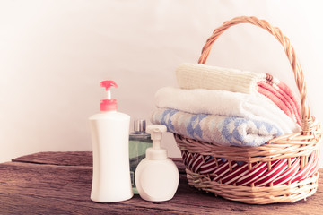 Shower gel with Skin cream and bath towels in basket