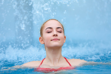 Beautiful young girl relaxing in thermal pool