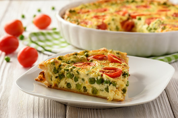 Vegetarian quiche with green pea, tomatoes and cheese.