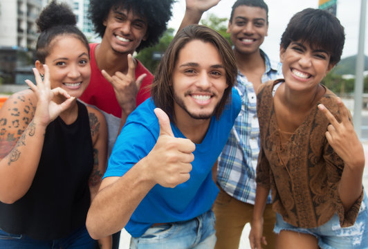 Group of international hipster young adults showing thumb