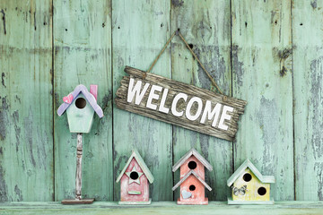 Welcome sign hanging over colorful spring birdhouses
