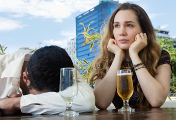 Drunken man with sad girlfriend in a bar