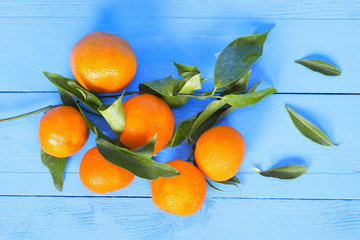 Tangerine heap with leaves on wood background