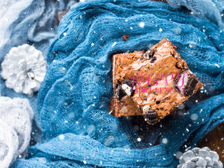 Cream cheese brownies with cookies on blue. Winter christmas treat square chocolate bars. Happy...