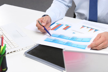 Businessman sitting on desk and writing a paper