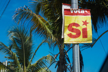 A political poster hanging of a street post.