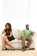 Couple: Man and Woman Sit Apart on Couch