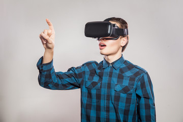 emotional funny man wearing virtual reality goggles. Studio portrait of video game designer wearing VR headset. studio shot isolated on gray background.