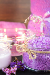 Obraz na płótnie Canvas Spa products. Lavender bath salts, dry flowers, cosmetic cream, light candles and towel. Violet purple concept. Coloring and processing photo.