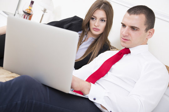 Close up of an couple in bed using a laptop.