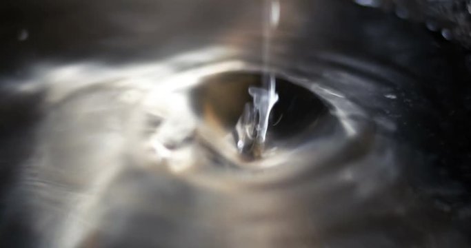 A macro shot of a water drops falling down on ater surface