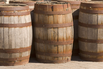 closeup of a row showing three wooden barrels