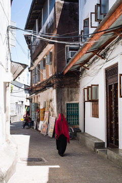 A woman wearing a Hijab walks through the alleyways of Stone Town, Zanzibar