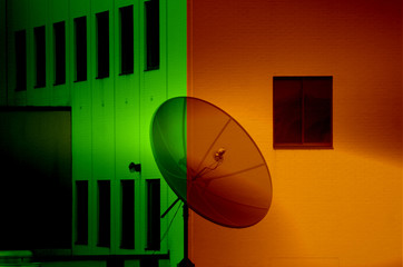 Satellite Dish Silhouette Against Colorful Building