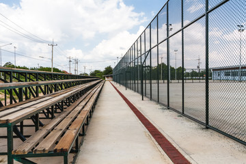 Rows of wooden grandstand empty seats of tennis field