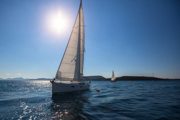 Obraz na płótnie Canvas Luxury yachts at Sailing regatta in the wind through waves at Sea.