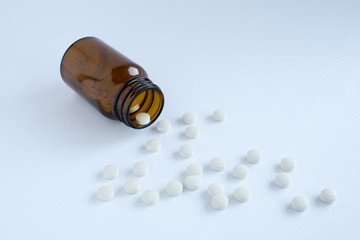 白い錠剤と茶色のガラス瓶
