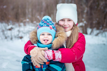 Little girl and boy in winter forest