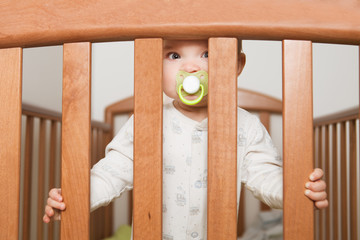 the baby with a pacifier costs in the bed

