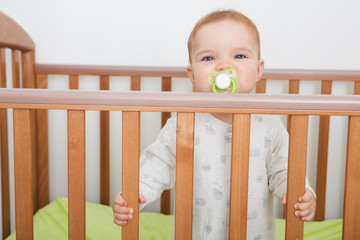 the baby with a pacifier costs in the bed

