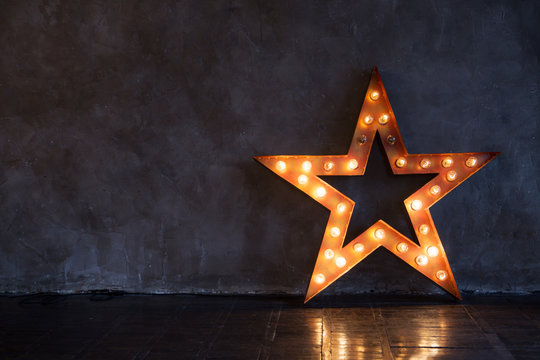 Decorative star with lamps on a background of wall. Modern grungy interior

