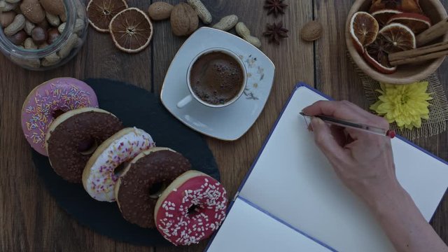 4k Donuts Composition on a Wooden Background with a hand writing I love donuts